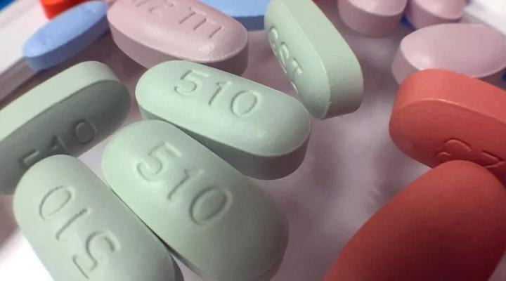 Close-up of pale green antiretroviral tablets among other coloured pills.